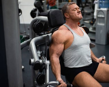 Spor salonunda büyük atletik adam trenler. Eğitim pazı