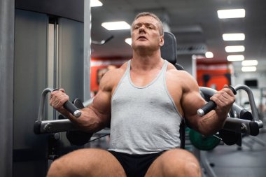 Spor salonunda büyük atletik adam trenler. Eğitim pazı