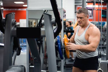 Egzersiz yapmak bir eğitim mermi büyük kaslı adam hazırlar