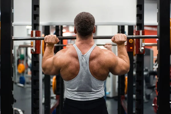 Gran Musculoso Entrena Sus Hombros Con Una Barra Gimnasio Concepto — Foto de Stock