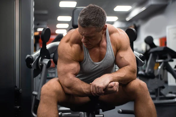 Spor salonunda büyük atletik adam trenler. Egzersiz sonrası dinlenme