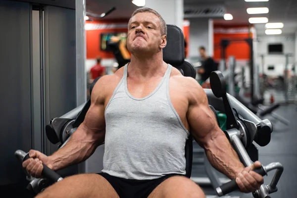 Spor salonunda büyük atletik adam trenler. Eğitim pazı