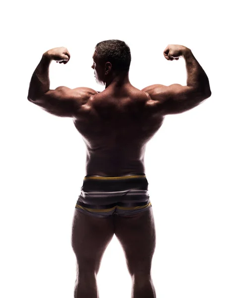 stock image Big powerful man shows off his biceps and back in Studio shirtless on white background