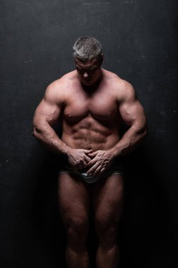 Studio grunge siyah duvar gömleği kasların gösterilen büyük güçlü bir adam