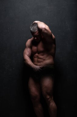 Studio grunge siyah duvar gömleği kasların gösterilen büyük güçlü bir adam