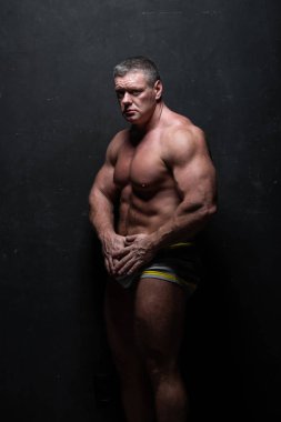 Studio grunge siyah duvar gömleği kasların gösterilen büyük güçlü bir adam