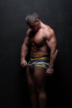 Studio grunge siyah duvar gömleği kasların gösterilen büyük güçlü bir adam