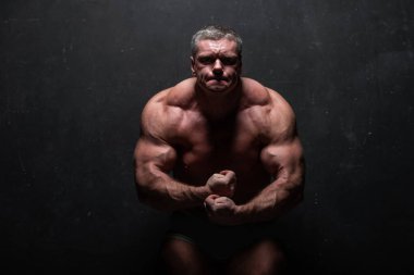 Studio grunge siyah duvar gömleği kasların gösterilen büyük güçlü bir adam