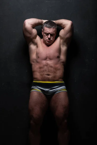 Duży Człowiek Potężny Pokazuje Jego Mięśnie Studio Bez Koszuli Ścianie — Zdjęcie stockowe