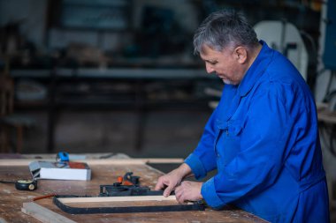 Tutkal ve farklı araçlar ile atölyesinde marangozluk masada ahşap çerçeve montaj