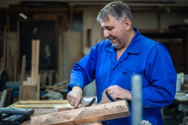 Olgun marangoz adam atölye ahşap bir çekiç ile uçak onarır