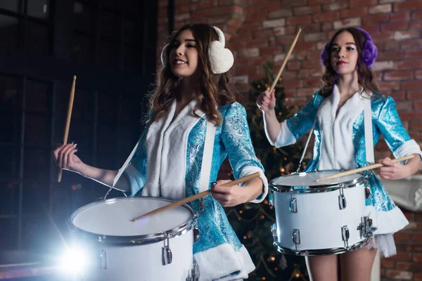 Russian Christmas snow Maiden characters, rock band, playing the drum in the Studio