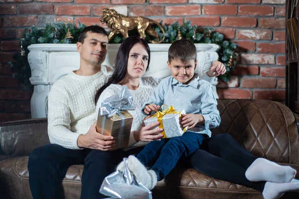 Christmas photo of a happy family around a decorated Christmas tree. Family celebrates New year