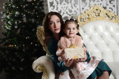 Mutlu Noeller ve mutlu tatiller. Güzel anne ve kızı ile Hediyelik Noel ağacı yakın: