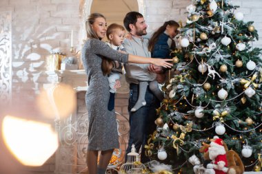 Mutlu bir aile Noel fotoğrafı. Baba, Anne, kızı ve oğlu ağaç süslemek