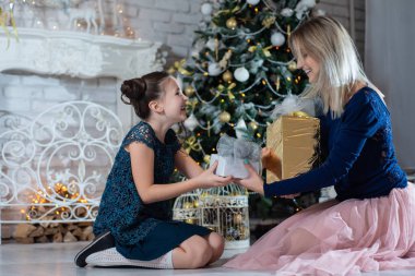 Mutlu Noeller ve mutlu tatiller. Güzel anne ve kızı eğlenmek ve hediyeleri Noel ağacı yakınındaki