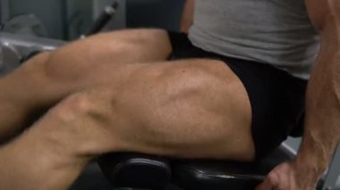 Kaslı adam bacaklarını salonunda eğitiyor. Sağlık ve fitness kavramı