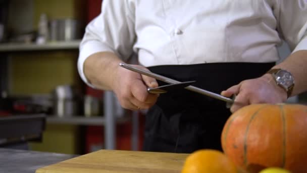 Cuchillo afilador de chef en cocina comercial para cocinar calabaza — Vídeo de stock