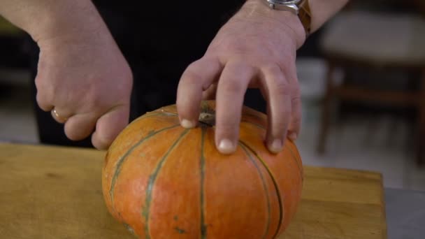 Chef cuts big pumpkin in half in the kitchen — Stock Video