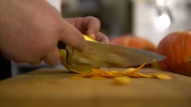 Cook turuncu closeup temizler. Meyve kabuğu elinde bir bıçak ile kesmek