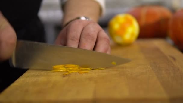 Chef-kok snijdt de sinaasappelschil in kleine stukjes close-up — Stockvideo