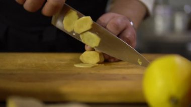 Şef mutfakta büyük bir kabak çorba pişirmek için küçük parçalar yakın çekim keser.