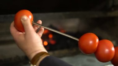Bir açık ateş üzerinde pişirme sebze. Hava, yiyecek ve keyfi pikniğe. Yangın closeup domates.
