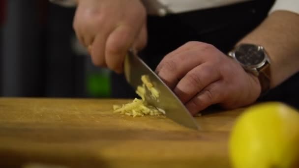 Chef coupe une grande citrouille dans la cuisine en petits morceaux gros plan pour faire cuire la soupe — Video