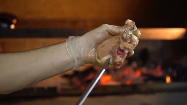 Barbacoa en la parrilla de cocción. Mano pone carne cruda en el pincho de cerca — Vídeos de Stock