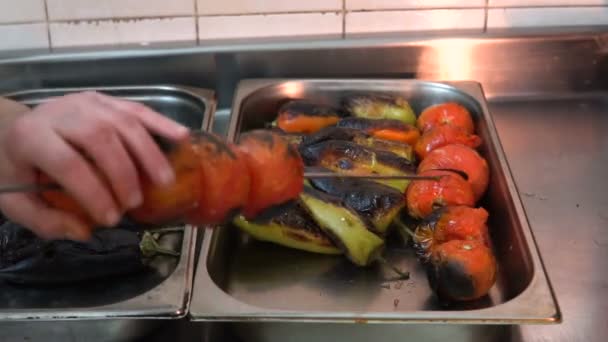 男子将烤蔬菜从烤串放在金属托盘上 — 图库视频影像