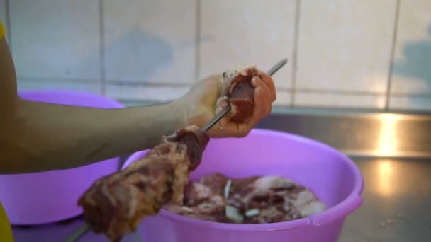 Mano pone carne cruda en el pincho primer plano en la cocina — Vídeos de Stock