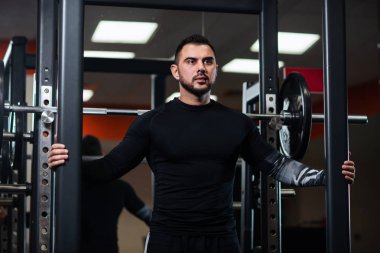 Yakışıklı siyah giysili halter yanında poz büyük kaslı