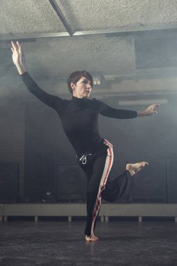 modern genç güzel dansçı duman stüdyoda karşı poz siyah giysili