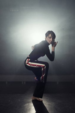 modern genç güzel dansçı duman stüdyoda karşı poz siyah giysili