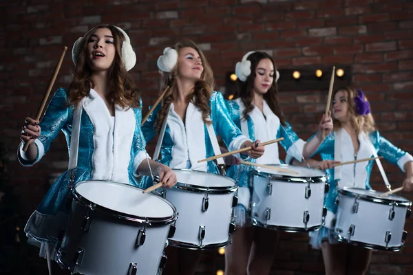 Russian Christmas snow Maiden characters, rock band, playing the drum in the Studio