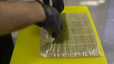 Şefin elleri Japon yemeği hazırlıyor, şef suşi yapıyor, suşi hazırlıyor.