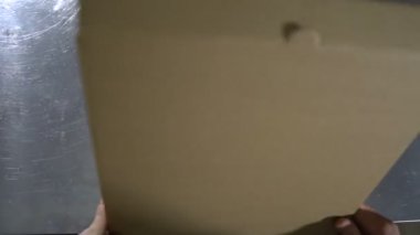 Pizza bir karton kutu koyar. En baştan görüntüleyin. Pizza teslim.