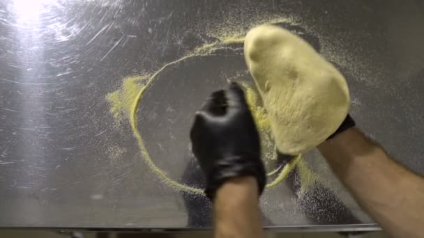 Cocine en la cocina prepara la base para la pizza, girando la masa en un círculo — Vídeos de Stock