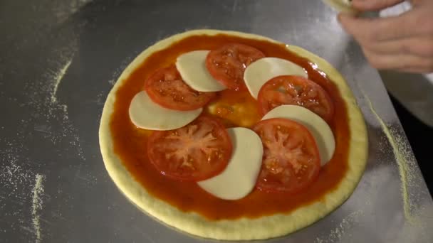Chef de mão coloca tomates e queijo no closeup pizza — Vídeo de Stock