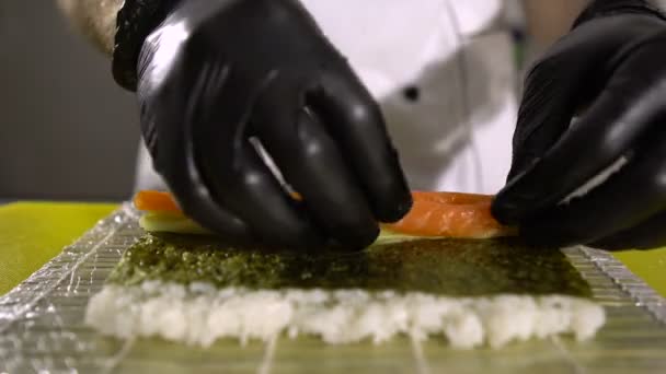 Ręce szefa kuchni przygotowujące japońskie jedzenie, kucharz przygotowujący sushi, przygotowujący sushi roll — Wideo stockowe