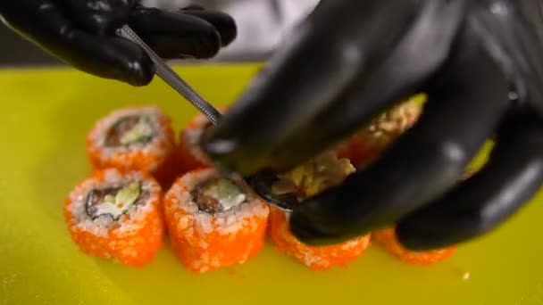 Mains du chef préparent des plats japonais, le chef fait des sushis, prépare des rouleaux de sushi, met une garniture très savoureuse — Video