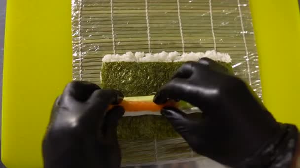Le mani dello chef preparano piatti giapponesi, lo chef fa il sushi, prepara il rotolo di sushi, mette un ripieno molto saporito — Video Stock