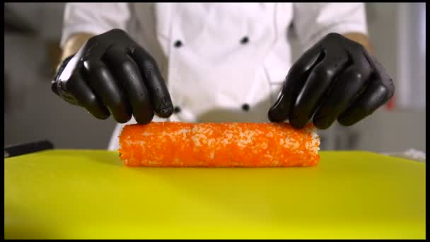 Manos de chef preparando comida japonesa, chef hace sushi, prepara rollo de sushi, cortarlos en pedazos — Vídeos de Stock