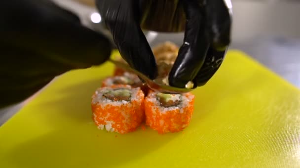 Tangan koki mempersiapkan hidangan Jepang, koki membuat sushi, menyiapkan roti gulung sushi, mengisi sangat lezat — Stok Video