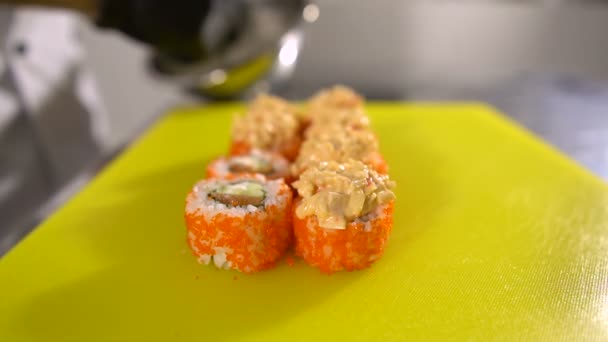 Mains du chef préparent des plats japonais, le chef fait des sushis, prépare des rouleaux de sushi, met une garniture très savoureuse — Video