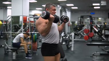 Rusya, Togliatti - 20 Eylül 2018: Atletik erkek trenler jimnastik salonu. Eğitim pazı bir dumbbells ile