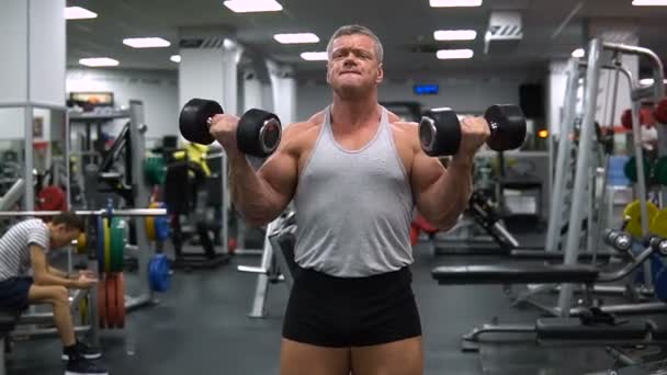 Oroszország, Togliatti - 2018. szeptember 20.: Sportos férfi a vonat az edzőteremben. A egy súlyzó edzés bicepsz — Stock videók