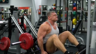 Rusya, Togliatti - 20 Eylül 2018: Bacaklarını jimnastik salonu kas adam eğitiyor. Sağlık ve fitness kavramı