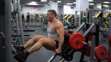 Rusya, Togliatti - 20 Eylül 2018: Bacaklarını jimnastik salonu kas adam eğitiyor. Sağlık ve fitness kavramı