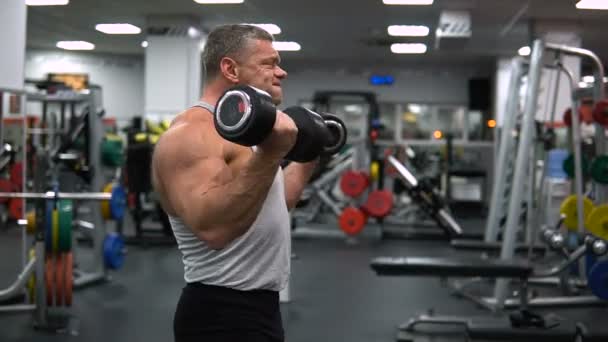 RUSIA, TOGLIATTI - 20 DE SEPTIEMBRE DE 2018: Hombre atlético entrena en el gimnasio. Entrenamiento de bíceps con mancuernas — Vídeos de Stock